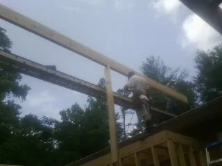 Carpenter setting a ridge beam over a new addition frame — Ice Dam Removal by Roofing Brothers in Ault