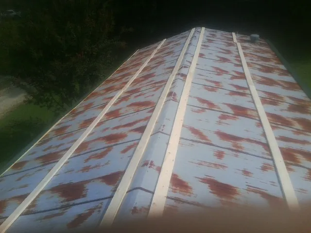Rusted metal roof panels with new wood purlins before replacement — Storm Damage Roof Repair in Ault by Roofing Brothers